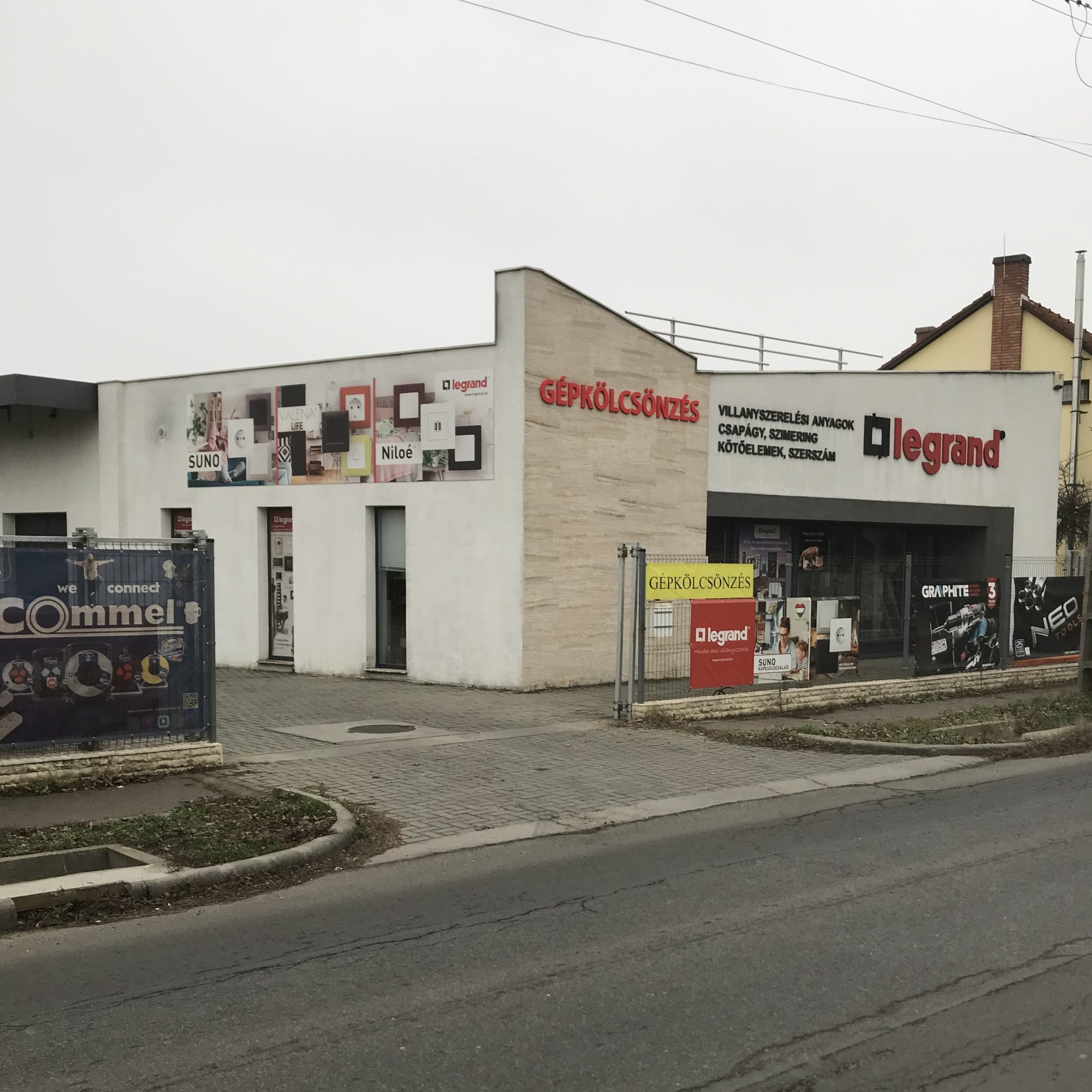 villanyszerelesi-szakuzlet-gepkolcsonzo-uzlet Villanyszerelési szaküzlet és gépkölcsönző üzlet homlokzata „Gépkölcsönzés” és „Villanyszerelési anyagok” felirattal.